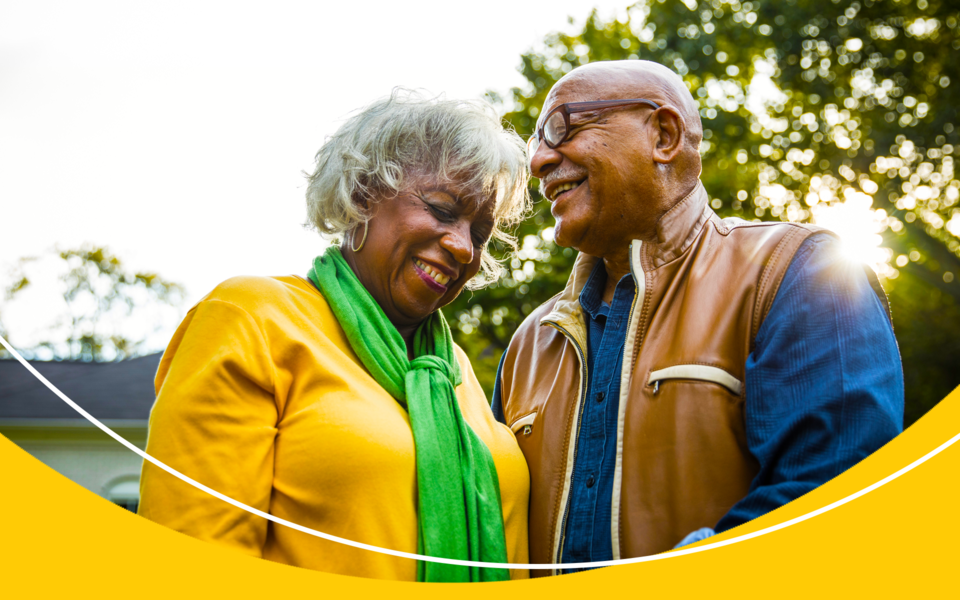 An elderly couple smiling in nature together