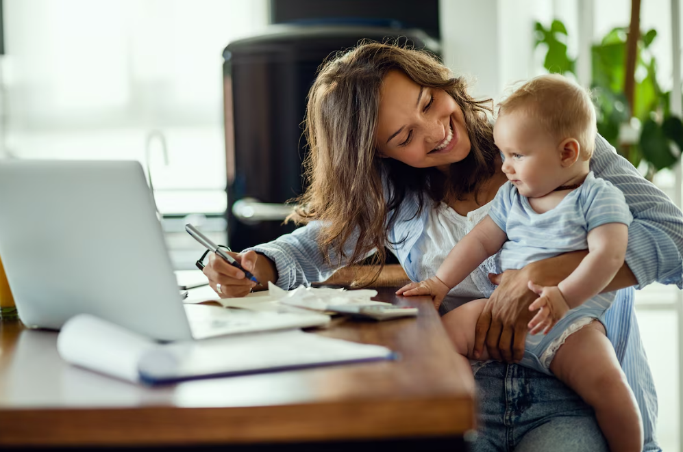 Mother and child sitting at a computer smiling