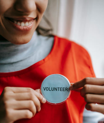 A woman wearing a volunteer badge
