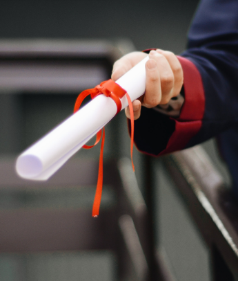 A graduate showing their degree scroll