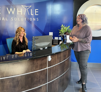 Two woman talking each other at office reception