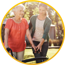 A young lady guiding an elderly woman while walking