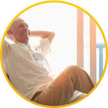 An elderly gentleman relaxing in his chair with his arms placed behind his head