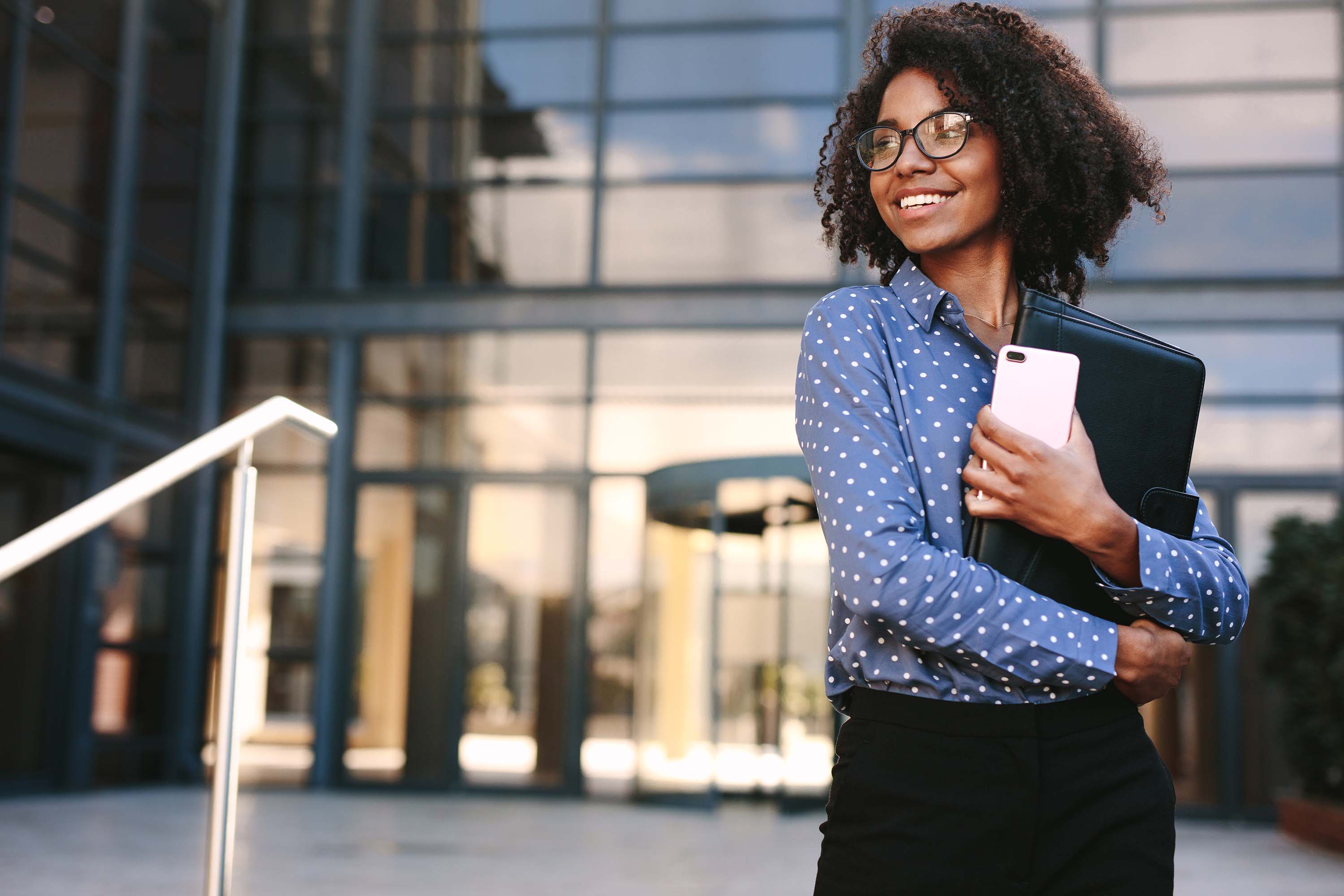 A professional woman standing outside of the office building