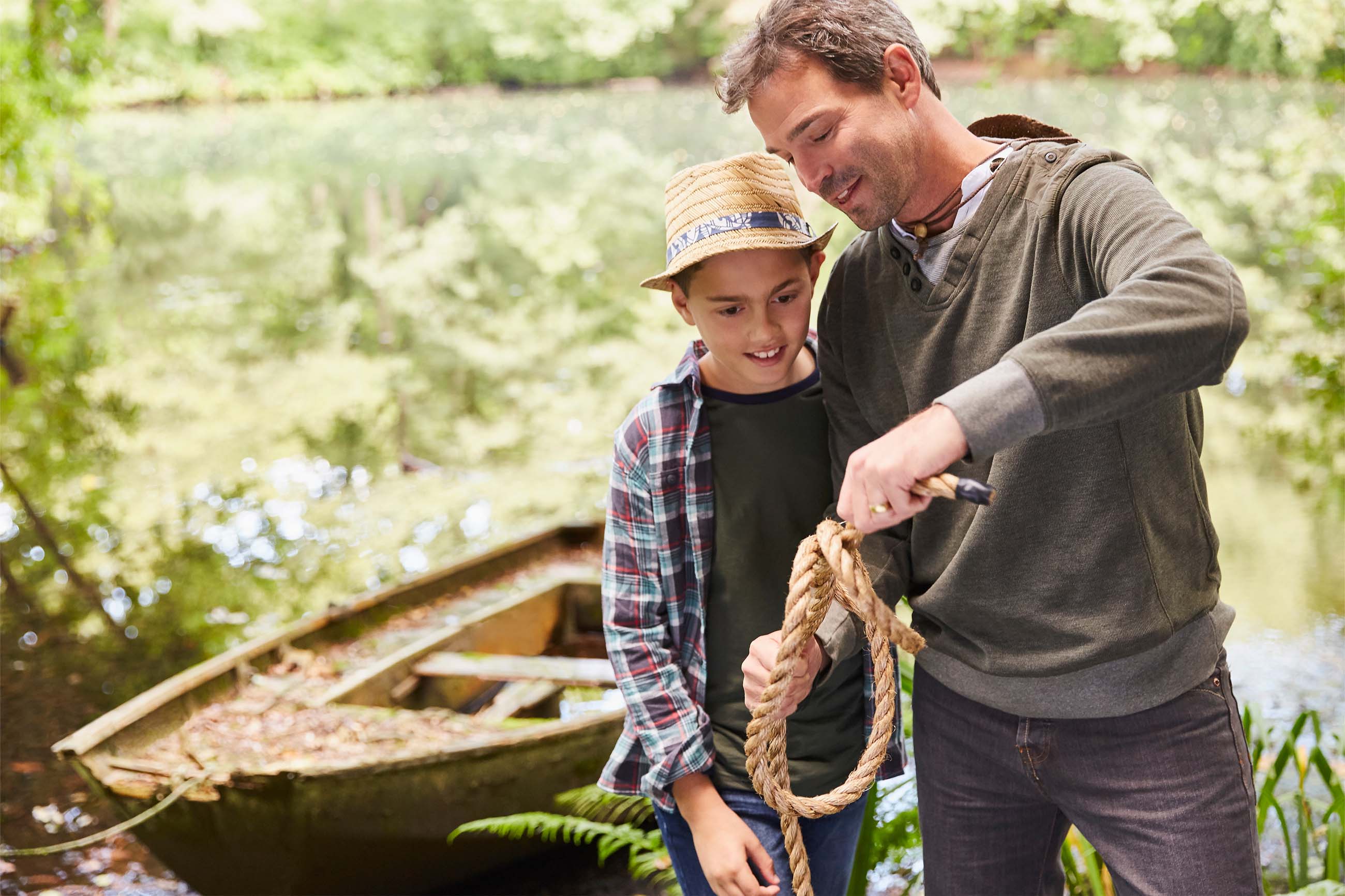 Father teaching son how to tie a rope knot