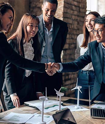 businesspeople shaking hands at meeting table