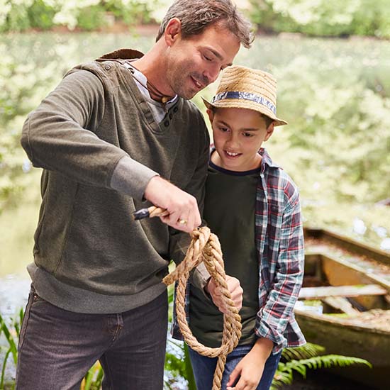 Father teaching son how to tie a rope knot